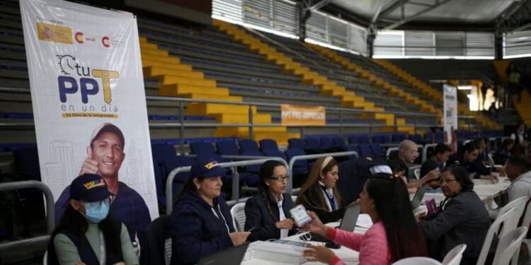 ARCHIVO - Empleados de Migración Colombia trabajan durante un día de entregas de Permiso de Protección Temporal (PPT) organizado por Migración Colombia en el Palacio de los Deportes en Bogotá, Colombia, 1 de septiembre de 2023.