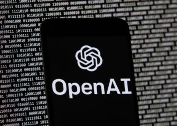 ARCHIVO - El logotipo de OpenAI aparece en un teléfono celular frente a la pantalla de una computadora, el 9 de marzo de 2023, en Boston.