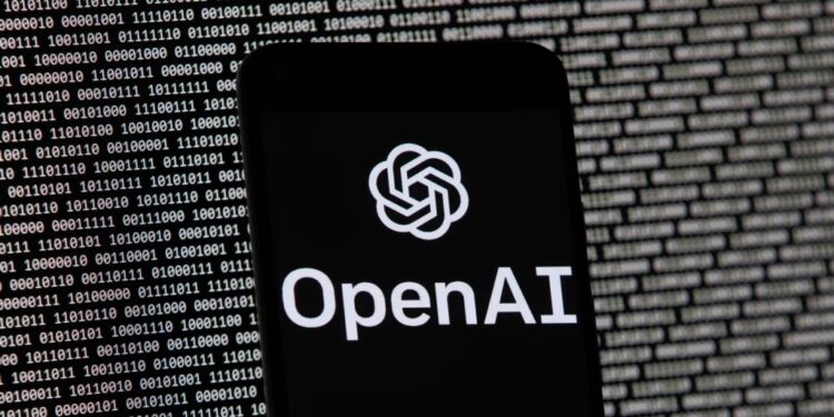 ARCHIVO - El logotipo de OpenAI aparece en un teléfono celular frente a la pantalla de una computadora, el 9 de marzo de 2023, en Boston.
