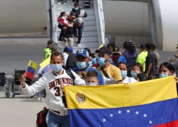Una familia venezolana posa con la bandera de su país al aterrizar en el aeropuerto internacional Simón Bolívar, de Maiquetía, La Guaira, el 24 de febrero de 2025. AP/Cristian Hernández