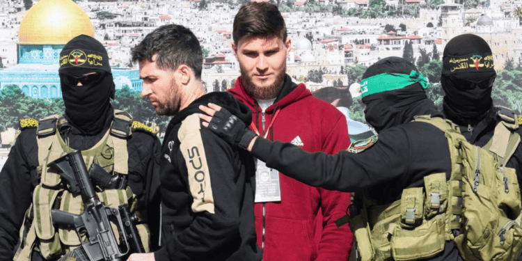 El estadounidense-israelí Sagui Dekel-Chen y el ruso-israelí Sasha (Alexander) Troufanov, rehenes retenidos en Gaza son escoltados por militantes palestinos de Hamás y de la Jihad Islámica como parte de un acuerdo de intercambio de rehenes, el 15 de febrero de 2025.