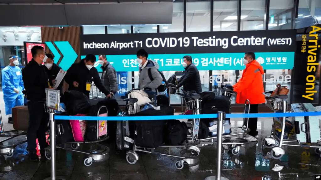 Los pasajeros que llegan de China pasan a un centro de pruebas de COVID-19 en el Aeropuerto Internacional de Incheon en Incheon, Corea del Sur, el 14 de enero de 2023.