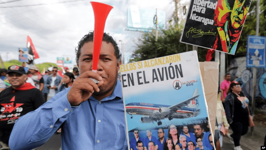 Un manifestante sostiene un cartel con un mensaje que dice en español; “Caben todos en el avión”, refiriéndose a los presos del gobierno del presidente Daniel Ortega que fueron liberados, despojados de su ciudadanía y trasladados a Estados Unidos.