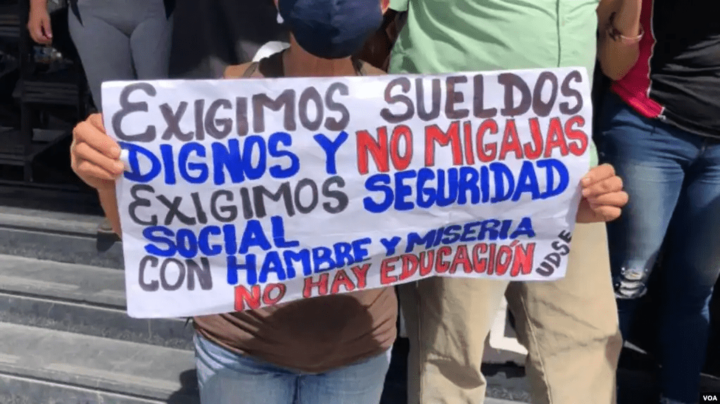 ARCHIVO - Una manifestante venezolana sostiene una pancarta en una protesta por mejores salarios, en Caracas. [Foto: Álvaro Algara, VOA]