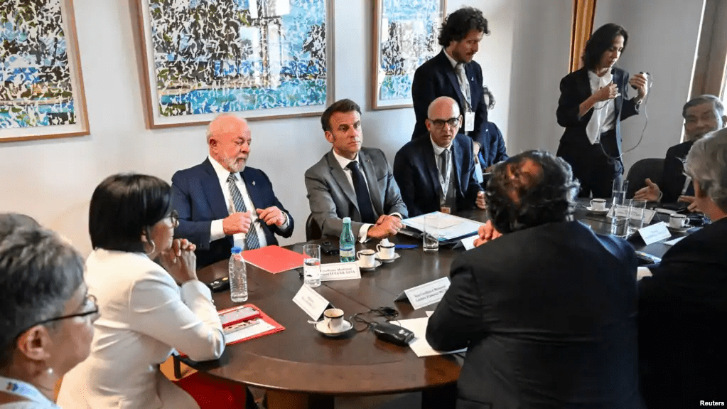 El presidente de Francia, Emmanuel Macron, lidera una reunión sobre el diálogo en Venezuela junto a 3 mandatarios latinoamericanos y delegados del gobierno de Nicolás Maduro y la oposición, en los extremos de la foto, en Bruselas, Bélgica.