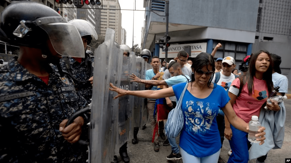 Manifestantes empujan los escudos de la policía venezolana mientras protestan contra el gobierno de Nicolás Maduro en Caracas, el 18 de Julio de 2018. La ONG Foro Penal reporta más de 15.000 presos por razones políticas en Venezuela desde 2014.