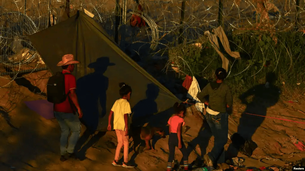 Migrantes que buscan asilo en Estados Unidos caminan cerca de una cerca con púas, en Ciudad Juarez, México. Estados Unidos y Venezuela acordaron un plan de repatriación con vuelos directos de quienes no tengan base legal para quedarse en el país norteamericano.