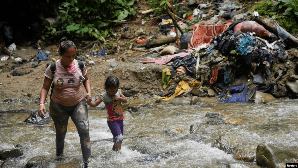 Una migrante camina junto a una niña en Acandi, Colombia, mientras continúan su camino a Estados Unidos, el 9 de Julio de 2023. Este año, siguen creciendo las cifras récord de migración a través del Tapón del Darién, que conecta a Colombia y Panamá.