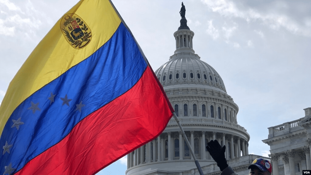 Venezolano sostiene su bandera frente al Capitolio de EE.UU., en Washington.