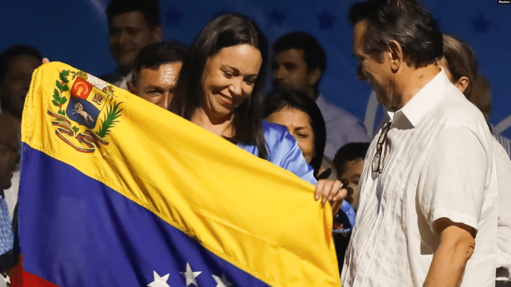 María Corina Machado, inminente ganadora de la primaria presidencial opositora, sostiene una bandera de Venezuela en su comando de campaña, amaneciendo este lunes 23 de octubre de 2023.