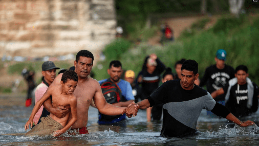 Migrantes venezolanos caminan por el río Grande en un intento de buscar asilo en EEUU, visto desde Piedras Negras, México, el 30 de septiembre de 2023. REUTERS/Daniel Becerril