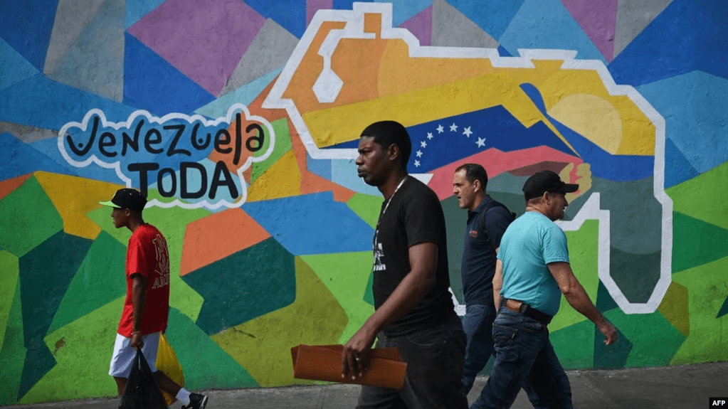Personas caminan frente a un mural en la comunidad del 23 de Enero, en Caracas, a favor del referendo consultivo sobre el Esequibo. La votación se realizará este domingo en toda Venezuela.