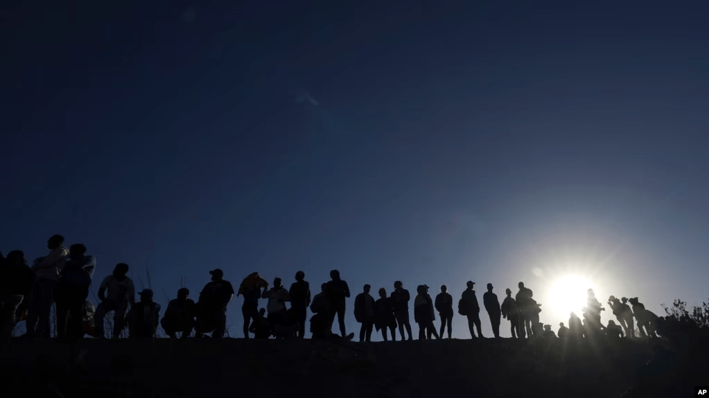 ARCHIVO - Migrantes se encuentran en el lado mexicano de la frontera entre Estados Unidos y México, a orillas del Río Grande, en Ciudad Juárez, México, el 29 de marzo de 2023.