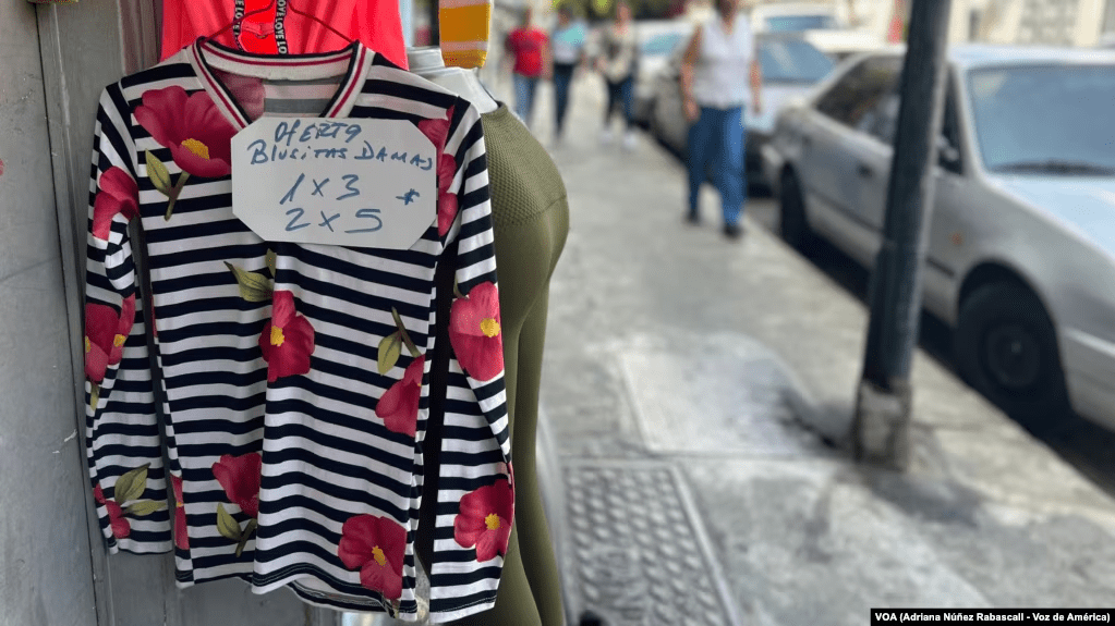 Una venta de ropa de algodón exhibe ofertas de sus prendas por hasta 2 piezas por 5 dólares en Caracas, Venezuela.