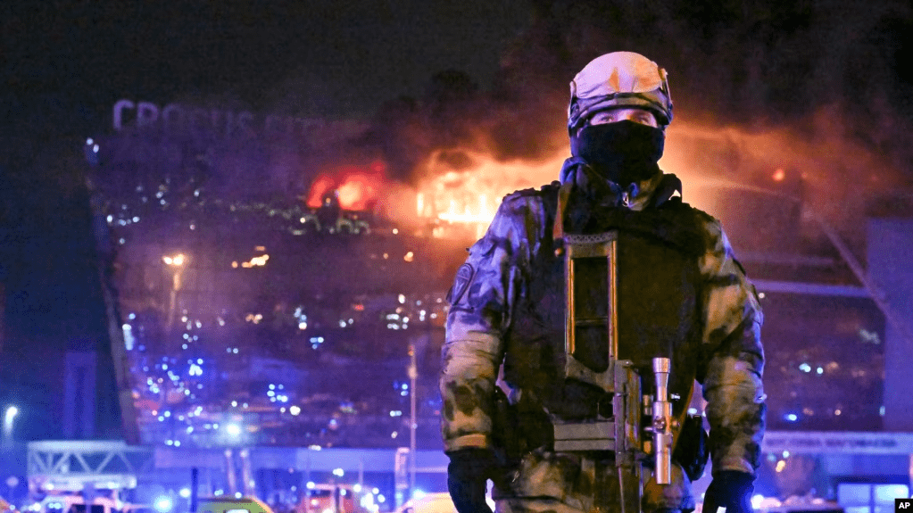 Un agente de las fuerzas de seguridad rusas apostado frente a la sala de conciertos Crocus City Hall, en llamas, en las afueras de Moscú, el 22 de marzo de 2024.