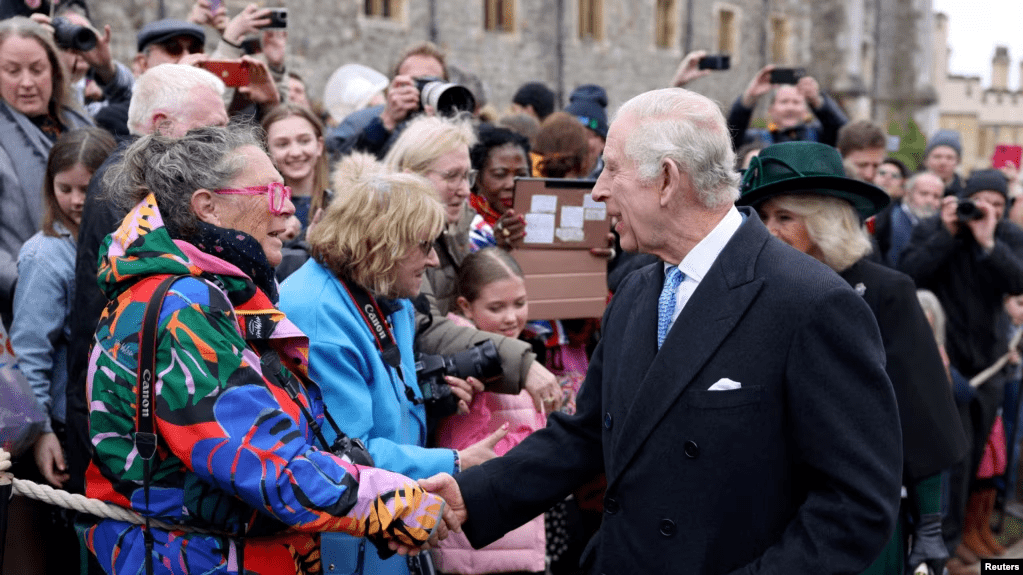 El rey Carlos de Inglaterra y la reina Camila saludan al público después de asistir al servicio religioso del Domingo de Pascua en la Capilla de San Jorge, en el Castillo de Windsor, el 31 de marzo de 2024.